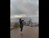 Black shirt mom photographs kid on rock
