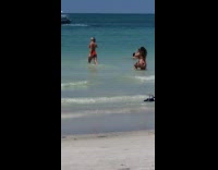 Red bikini girl walks further into ocean 