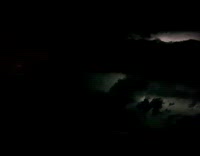 Lightning flickers behind clouds from the airplane