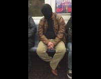 Black beanie hat covers face on train