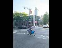 Biker balances bottle on head 