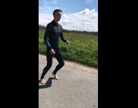 man in black wet suite does stretches