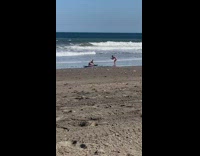 Girl sits waxes surfboard beach sand 
