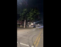 Woman show her car flipped over on sidewalk