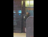 Man red hat talking to black wall 