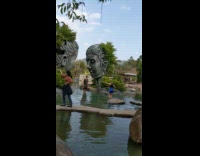 Tourists pose with giant buddha head