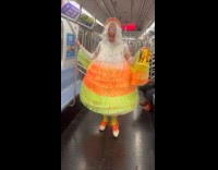 Woman wears candy corn costume on subway