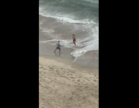 Guy black shorts kicks punches air beach 