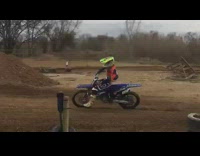 guy in orange jumpsuit rides purple motorcross bike 