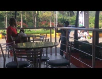 Red dress lady poses restaurant patio table 