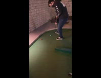 Guy hits golf ball away from hole 