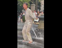 Man in white jumpsuit eyes rolled back dances