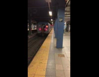 Two boys hold onto back of subway train