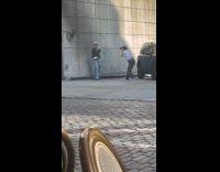 Man poses front of parking lot wall