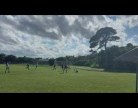 Girl kicking ball into net loses balance and falls 