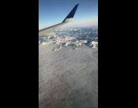 Airplane view grey clouds over  mountain valley