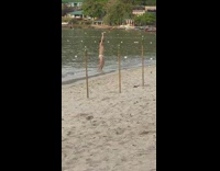 Man in speedos dance beach torch pole