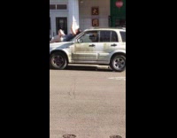 Woman lie down on the car hood of the dirty car