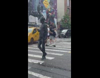 Couple standing atop a shared electric longboard on the street