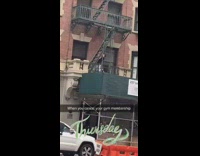 Guy does pull ups on fire escape ladder