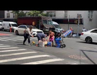 People helping man pick up dropped fruits on street