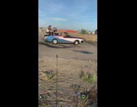 Guy plays drums blue convertible car smoke