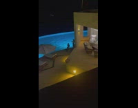 Woman poses at the poolside with flashes on camera
