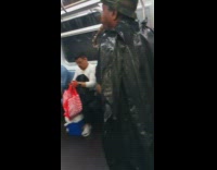 Man in camouflage hat and trashbag plays the saxophone on subway