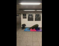 Man does yoga stretches on mat in subway station