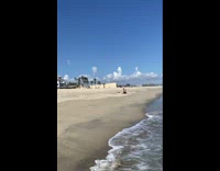 Woman pink bikini white beach hat run towards photographer