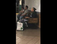 Old woman sits on bench and smokes inside subway station 