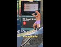 Man plays the flute in purple boxers on sidewalk