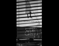 Man spray paint graffiti underneath billboard night