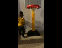 Toddler plays with small basketballs
