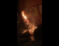 Christmas tree on fire on the sidewalk 
