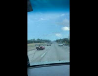Man drives red convertible with a surfboard