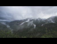 Clouds climb up on mountain time lapse