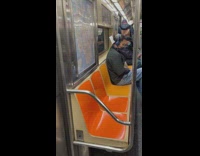 Man on subway has paper stuck on his hair 