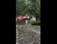 Delivery rider venturing flood with bike 