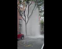 burst fire hydrant high water next to red car