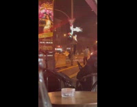 Man raps on a ladder beside the lamppost