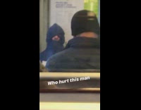 Man sits on metro train with hoodie scrunched and pulled over face 