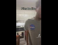 Guy grey shirt pretending to be fly in kitchen 