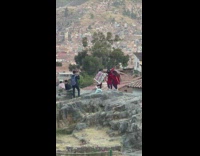 Three girls with weaved cloth dance on rock