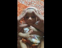 Guy squishes face baby white onesie windows 