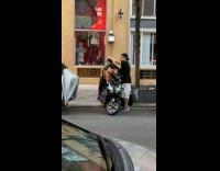 Man on motorcycle get haircut from barber