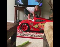 Little boy falls off toy red car 
