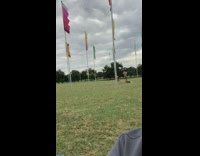 Red shorts guy poses flag pole grass