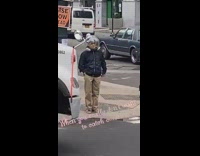 Guy wears clear bubble helmet outside sidewalk 