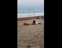 Woman black one piece bikini lie down beach sand